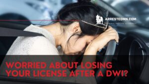 Distraught woman in a car holding the steering wheel, seatbelt on, overlaid with a DUI license-loss ad message.